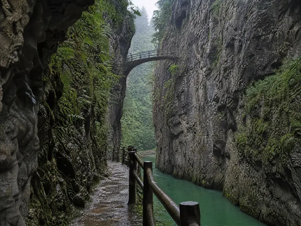 Un piccolo ponte pedonale che attraversa la gola in alto sopra l'acqua